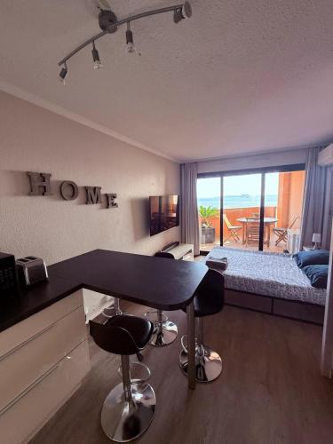 un salon avec une table et un lit ainsi qu'une chambre dans l'établissement Magnifique vue mer, à Cannes