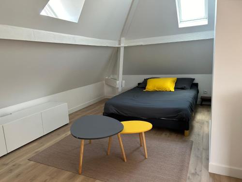 - une chambre avec un lit, un tabouret et une table dans l'établissement Appart hôtel Doumer, à Triel-sur-Seine