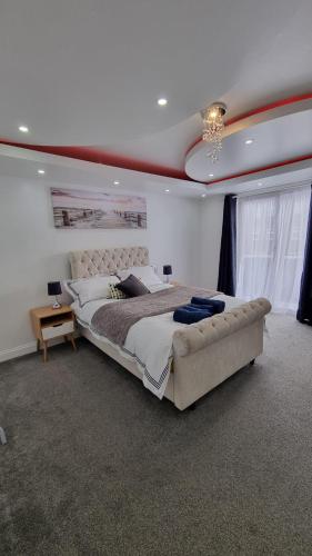 Habitación grande con cama grande y lámpara de araña. en Modern Elegant Home, en Portsmouth