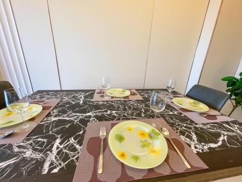 a dining room table with plates and forks and napkins at Luxury 1BR across Okada, Solaire in Manila