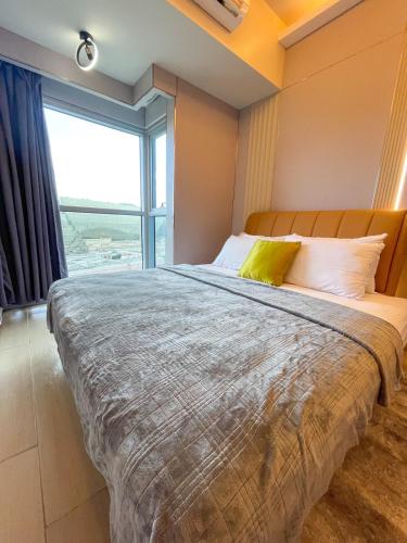 a bedroom with a large bed with a large window at Luxury 1BR across Okada, Solaire in Manila