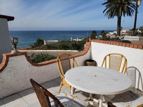 a white table and chairs on a balcony with the ocean at Ocean view house - Plaza del Mar in Rosarito