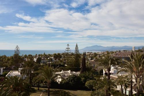a view of a city with palm trees and the ocean at Kimpton Los Monteros Marbella by IHG in Marbella