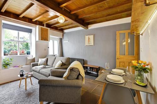 a living room with a couch and a table at Waterview Cottage - a peaceful riverside location in Holmfirth