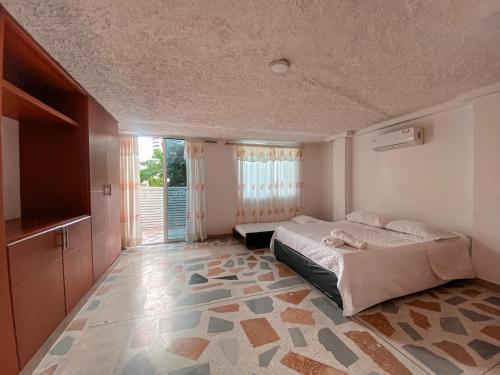a bedroom with a bed and a large window at Hotel Cabañas Villa Roca, Rodadero in Santa Marta