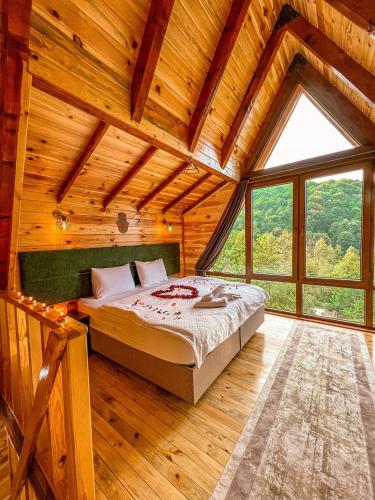 a bedroom with a bed in a wooden house at Şifaköy Bungalov in Sapanca