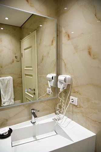 a bathroom with a sink and a mirror at Hotel Restaurant Dreri in Tirana
