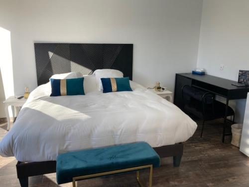 a bedroom with a large white bed with a desk at Hôtel Des Argousiers in Ambleteuse