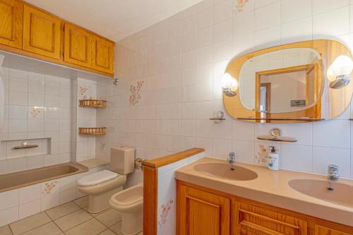 Un baño con lavabo, inodoro y espejo. en Casa Leila, en Puerto Naos