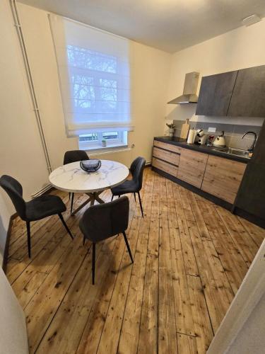 une pièce avec une table et des chaises et une cuisine dans l'établissement Appartement Spacieux 4 Chambres, à Flers-en-Escrebieux