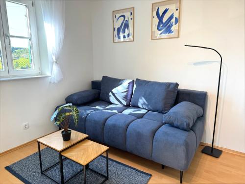 a blue couch in a living room with a table at Kellerstöckl - Zur Weinrebe in Eisenberg an der Pinka
