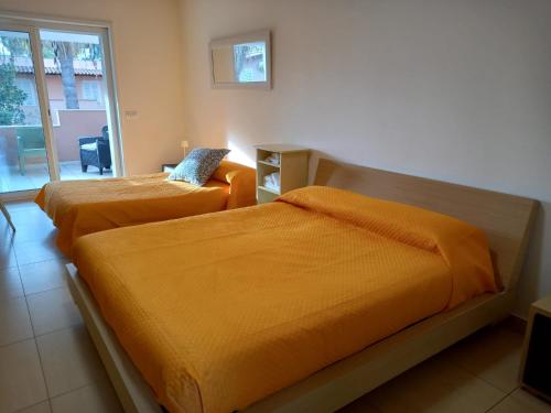 two beds with orange sheets in a room at Gemme di Portorosa in Furnari