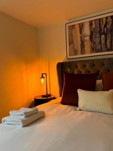 a bedroom with a bed with towels on it at Cosy Hideaway 7 min from Soho farmhouse in Enstone