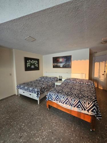 deux lits côte à côte dans une pièce dans l'établissement Departamento vista al mar y acceso a playa en bahía de Acapulco - Torres Gemelas, à Acapulco