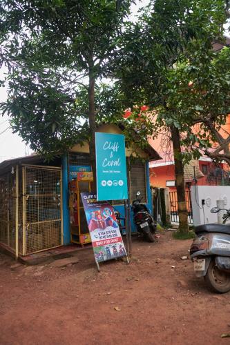 a sign sitting in front of a building with a sign at Cliff and Coral Varkala, North Cliff in Varkala