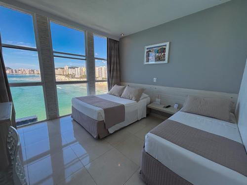 Cama ou camas em um quarto em Grand Hotel Guarujá - A sua Melhor Experiência Beira Mar na Praia!