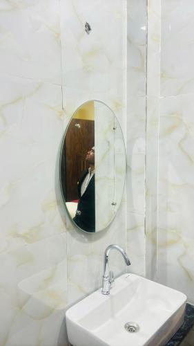 a person taking a picture of a bathroom mirror at Hotel AL Taj , Agra in Agra
