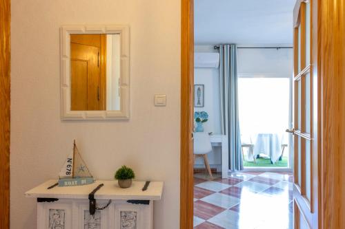 een kamer met een spiegel aan de muur en een tafel bij Todimer Ohana Beach in Salobreña