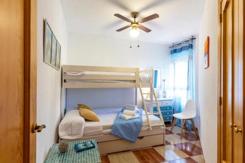 een slaapkamer met een stapelbed en een plafondventilator bij Todimer Ohana Beach in Salobreña