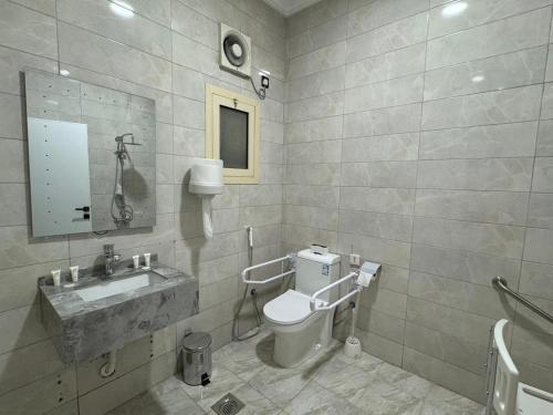 a bathroom with a toilet and a sink at حِمى التحلية للشقق المخدومة in Jeddah