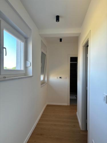 an empty room with a window and wooden floors at Villa Zlata in Privlaka