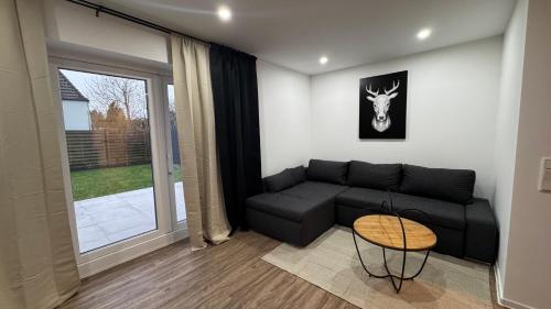 a living room with a black couch and a table at Ferienwohnung-Monteurwohnung ANTON bis zu 4 Personen in Kleve, zentrale Lage in Kleve
