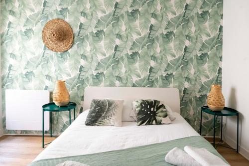 une chambre avec un lit avec un papier peint vert et blanc dans l'établissement Appartement dans quartier pittoresque, à Caen
