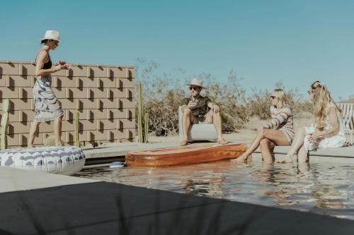 a group of people sitting in the water at Escondite: Modern Desert Hideout w Pool + Spa in Landers