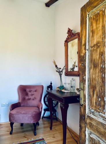 a room with a chair and a table and a mirror at Joyard - Pensiune & Parc in Porumbacu de Sus