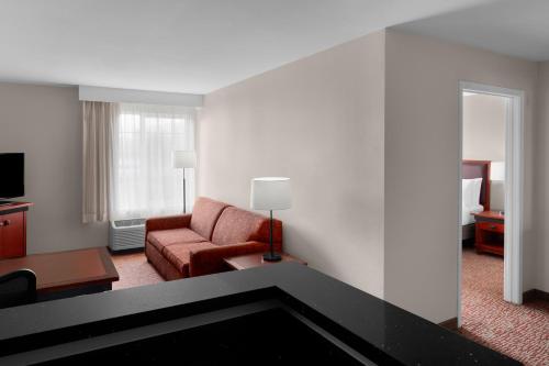 a living room with a couch and a chair in a hotel room at Larkspur Landing Extended Stay Suites Roseville in Roseville