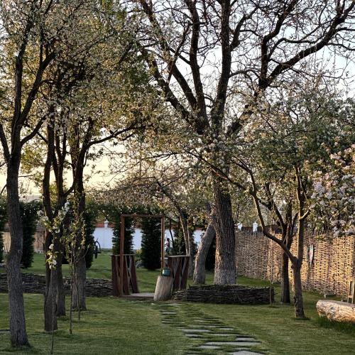 a group of trees in a park with a brick wall at Joyard - Pensiune & Parc in Porumbacu de Sus