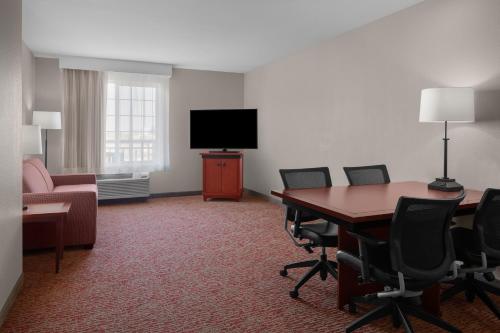 a room with a table and chairs and a television at Larkspur Landing Extended Stay Suites Roseville in Roseville