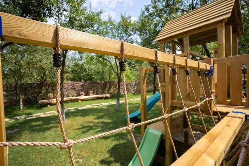 a swing set in a backyard with a playground at Joyard - Pensiune & Parc in Porumbacu de Sus
