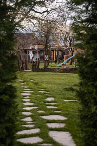 a stone path in a park with trees at Joyard - Pensiune & Parc in Porumbacu de Sus