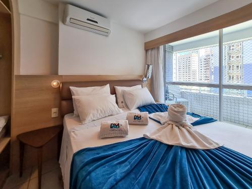 two beds in a hotel room with a large window at Beach Class Queridinho Apto 2Qtos 50m Praia in Fortaleza