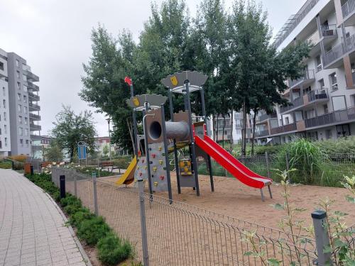グダニスクにあるLive like a local 5th FLOOR apartmentの公園内の滑り台のある遊び場