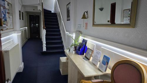 a hallway with a staircase with a table and a stair case at The Fairhaven Hotel in Nottingham
