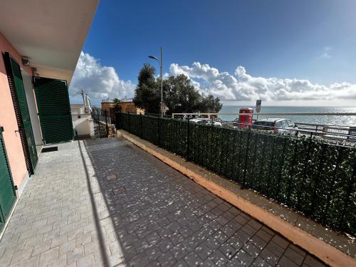 a walkway next to a house with the ocean in the background at Casa SERGE vista mare con ampio terrazzo privato in Bergeggi