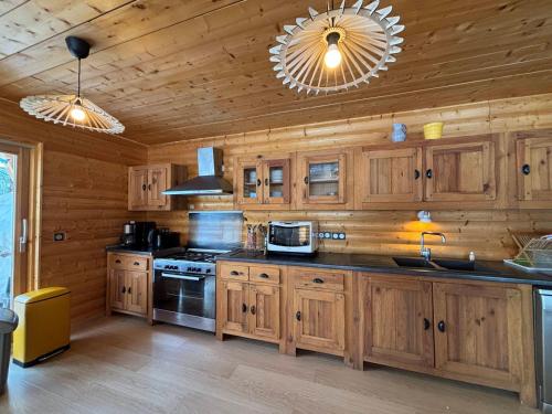 une cuisine avec des armoires en bois et un four à plaques de cuisson dans l'établissement Maison lumineuse 3 chambres à Méaudre - 8 pers, près des pistes - FR-1-737-3, à Méaudre