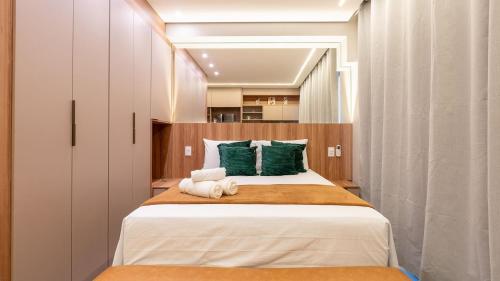 a bedroom with a large bed with green pillows at By DH: Luxo e conforto em Perdizes, aos poucos minutos do Allianz parque in Sao Paulo