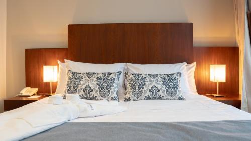a bedroom with a bed with two lamps and a phone at Parc Royale Suites Hotel in Cuenca