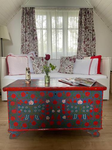 a living room with a red table with flowers on it at Itt és Most - Szent György-hegy in Raposka