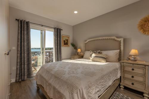 ein Schlafzimmer mit einem Bett und einem großen Fenster in der Unterkunft Villa Palma in Zaton