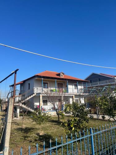 a white house with a red roof and a fence at Bert-House close to the sea in Lezhë