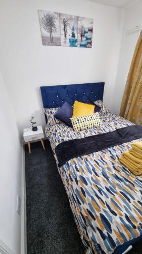 a bed with a blue headboard in a room at Cosy Retreat Your Home Away in Portsmouth