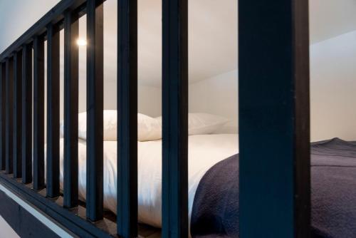 Bett mit weißer Bettwäsche und Kissen auf dem Balkon in der Unterkunft Appartement proche Place Saint-Sauveur in Caen