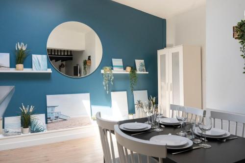 ein Esszimmer mit einem Tisch mit Stühlen und einem Spiegel in der Unterkunft Appartement proche Place Saint-Sauveur in Caen