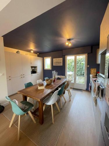 une cuisine et une salle à manger avec une table et des chaises en bois dans l'établissement Maison Familiale idéale pour les Vacances/Weekends, à Dinard