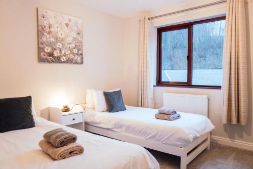 a bedroom with two beds and a window at Bellman's Hideaway in Bowness-on-Windermere