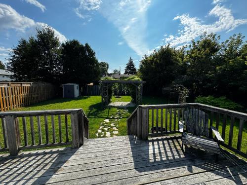 a wooden deck with a gate and a bench at Cozy room in Sudbury in Sudbury